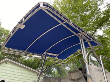 Blue fabric canopy on a boat with metal frame and seats.